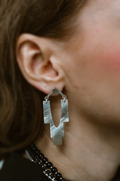 Srebrne kolczyki Cascada silver na uchu, nowoczesna biżuteria geometryczna